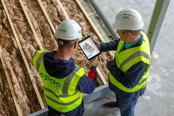 Restoration crew reviewing a job on a tablet inside a house under repair